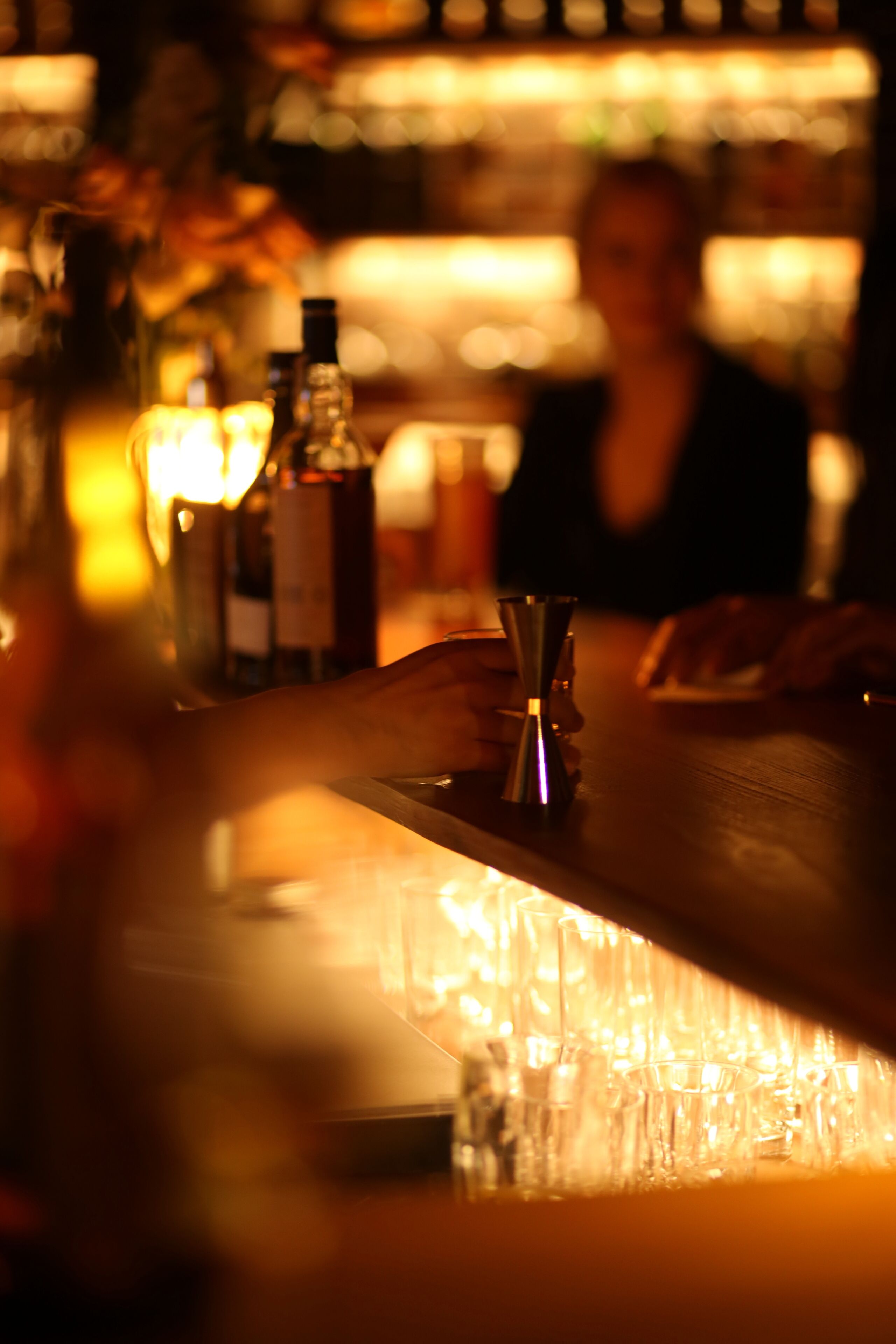 A bar area with bottles and glasses.