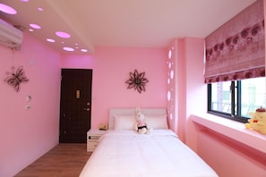 A pink-themed bedroom with a bed, a plush toy, decorative wall art, and a window with a view.