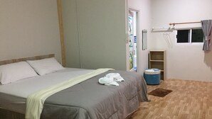 A bedroom with a bed, a wardrobe, a window with curtains, a small stool, and a shelf. - Plainam Resort (Pranburi)