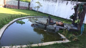 A small, oval-shaped pond with a decorative snake sculpture and a turtle sculpture on the edge. - Plainam Resort (Pranburi)
