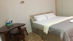 A bedroom with a bed, a wooden desk, and a chair. - Plainam Resort (Pranburi)
