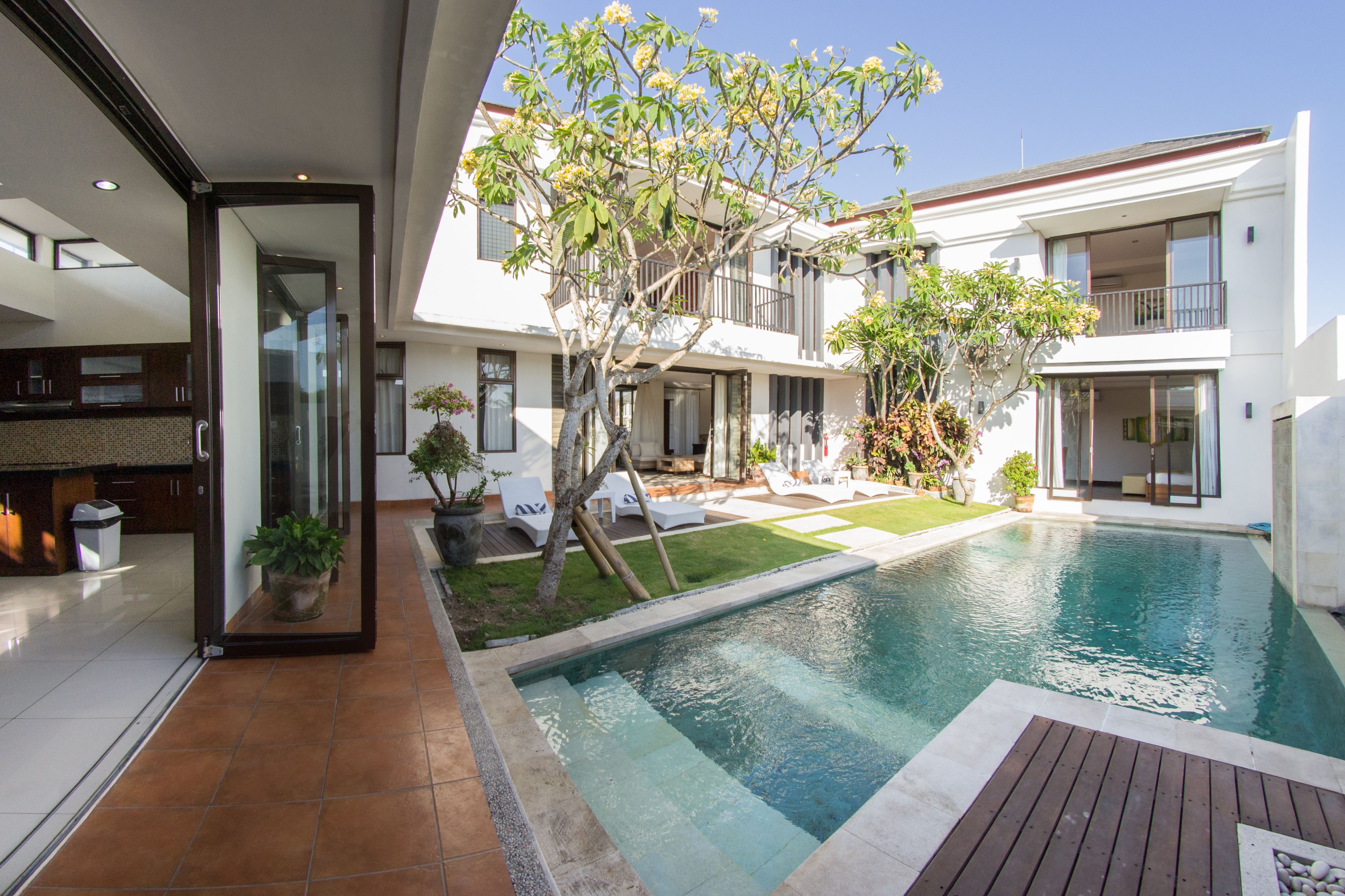 Une maison moderne dotée d’une piscine, d’une terrasse et d’un jardin.