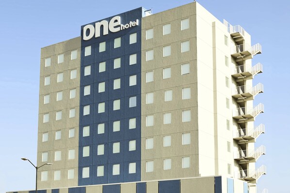 Un hotel de varios pisos con un llamativo letrero que dice 'one hotel' en la fachada.