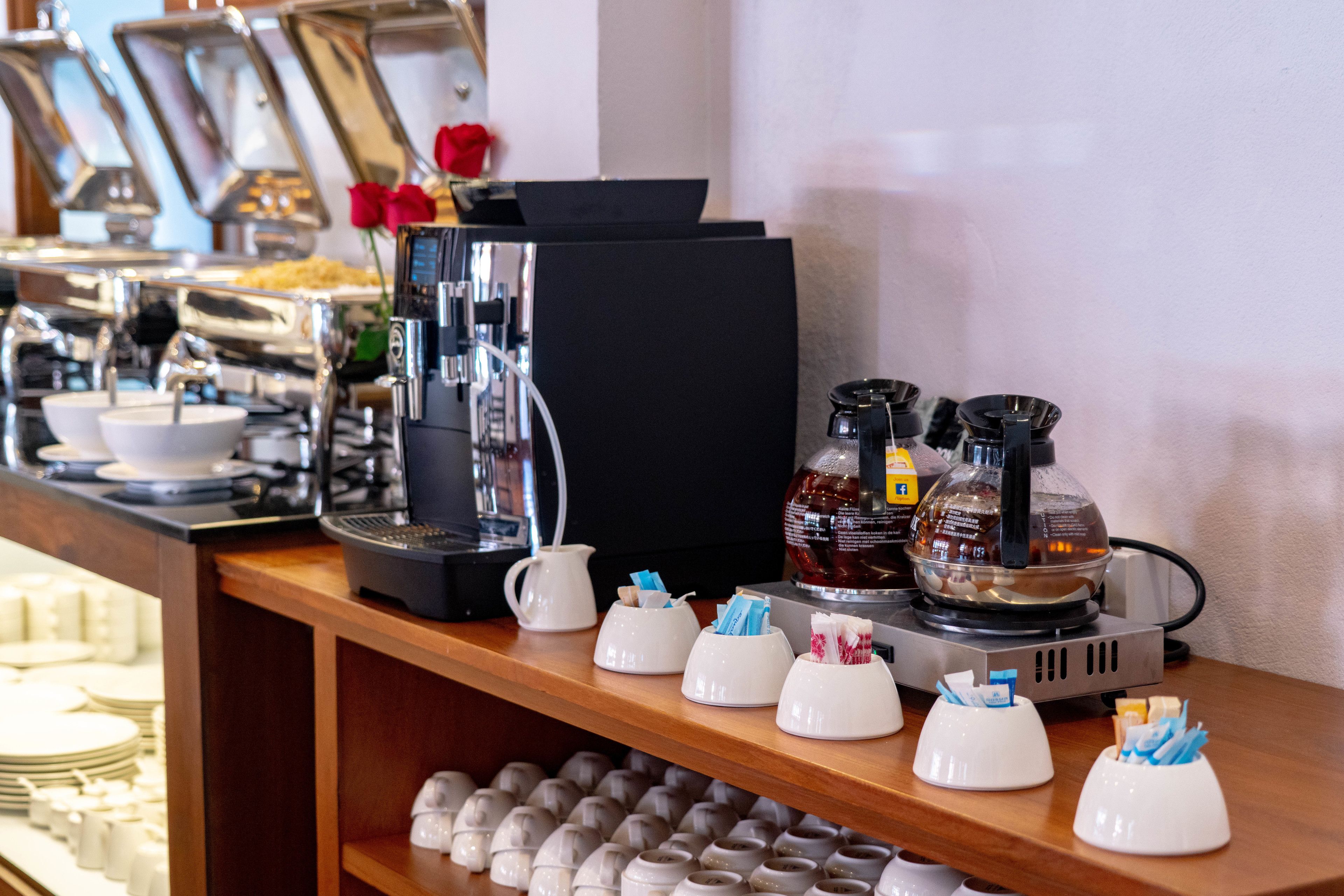 Un buffet con diversos alimentos y una máquina de café.