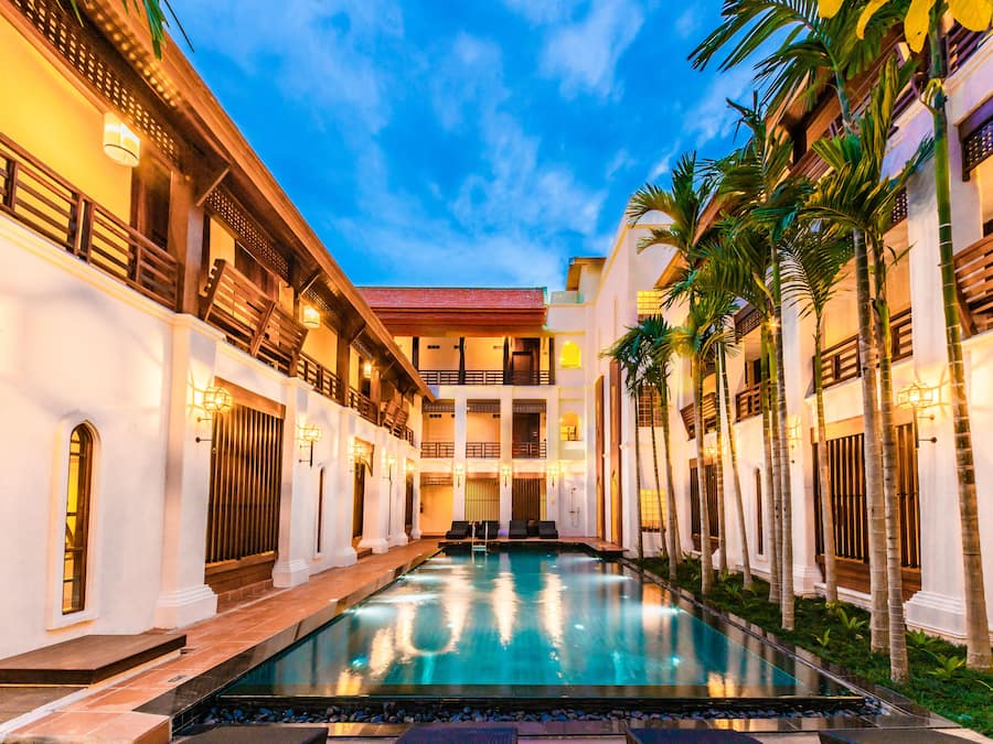 Una piscina al aire libre, sombrillas, sillones reclinables de piscina