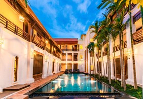 Una piscina al aire libre, sombrillas, sillones reclinables de piscina