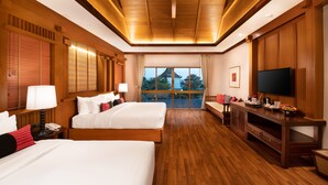 A hotel room with two beds, a TV, a desk, and a balcony with a view. - Phra Singh Village (Chiang Mai)