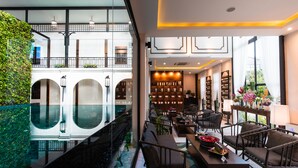 A modern hotel lobby with a glass-bottomed pool, seating area, and a view of the upper floor. - Phra Singh Village (Chiang Mai)
