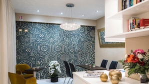 Um interior moderno com parede estampada, balcão de recepção, área de estar e estante de livros.