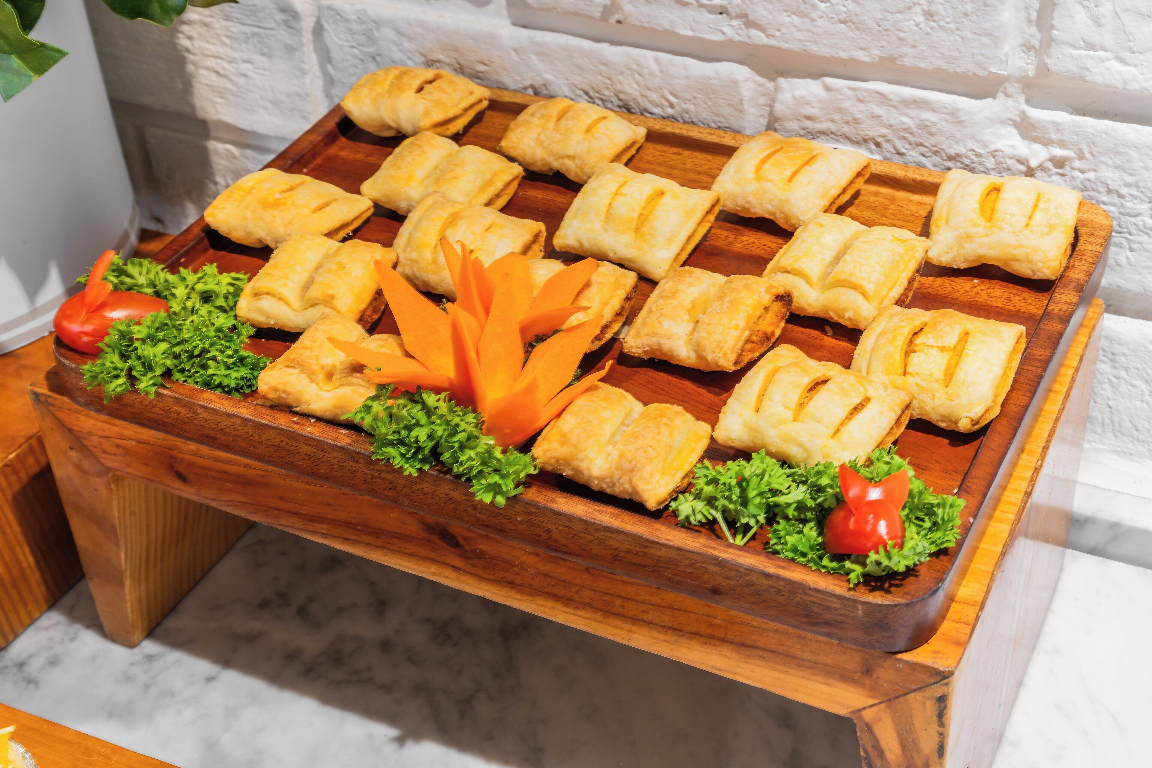 A wooden tray with pastries and garnishes.