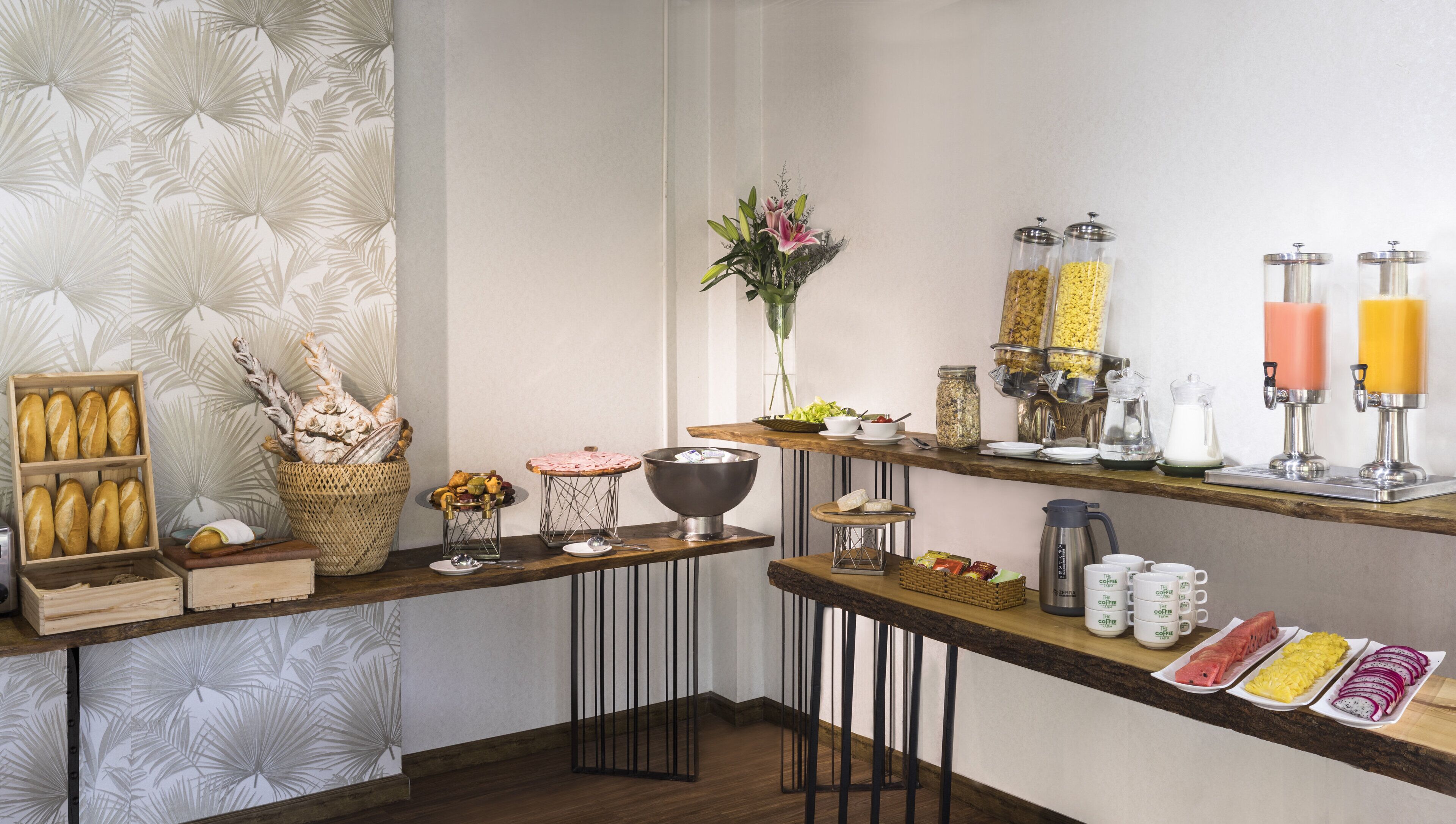 Um buffet de café da manhã com pães, bolos, frutas e bebidas.