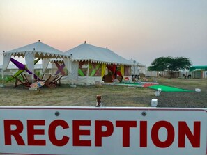 A reception area with tents and a sign indicating a reception.