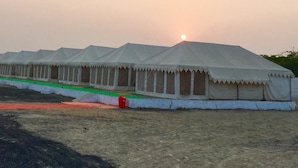 A row of white tents with a flat roof, arranged in a linear fashion.