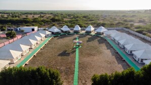 A series of white tents arranged in a semi-circular layout with a central pathway.