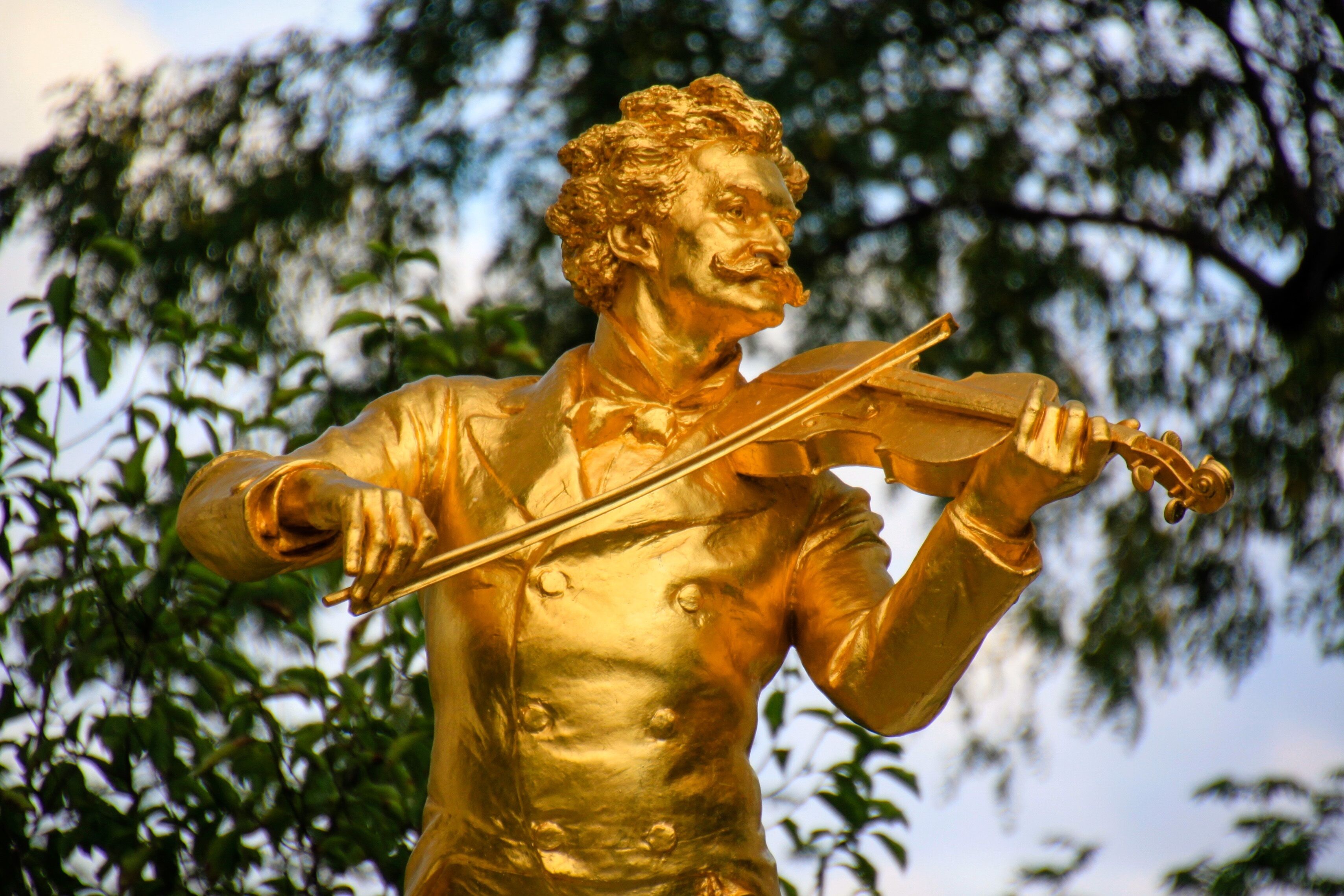 A golden statue of a man playing a violin.
