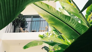 Un bâtiment moderne doté de balcons et agrémenté de grandes plantes vertes.