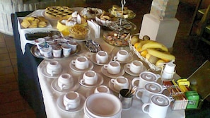 Une table de buffet avec divers plats et des services à thé.