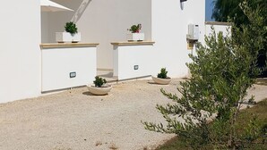Un edificio moderno con paredes blancas, antenas parabólicas y plantas en macetas.