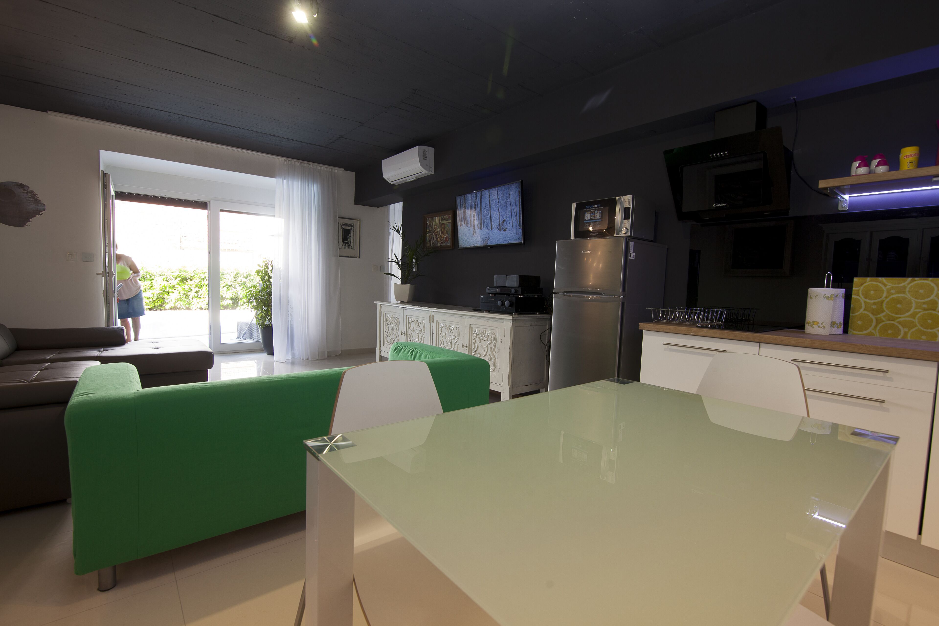 Una cucina moderna con zona pranzo, divano e televisione.