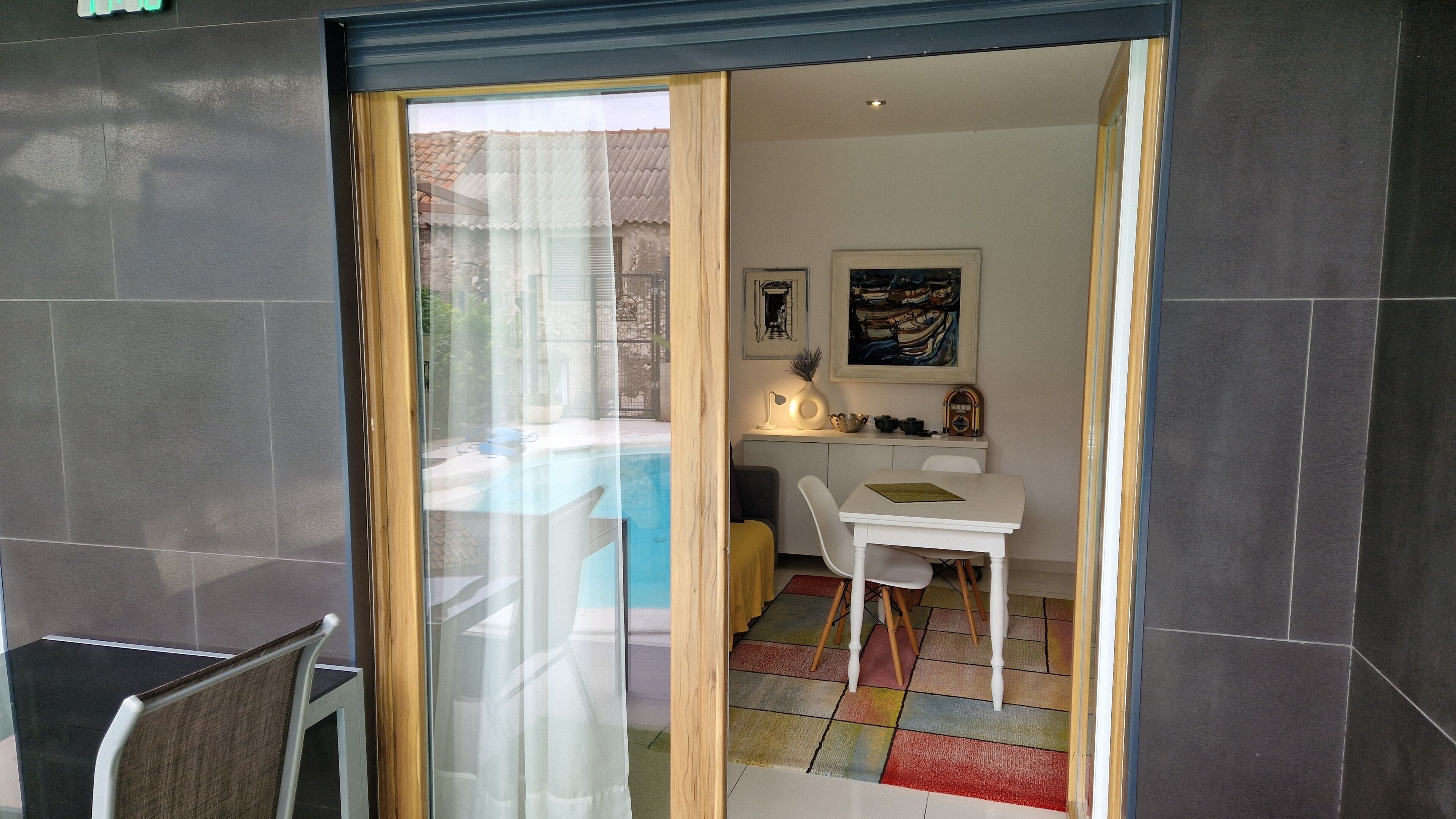 Una habitación moderna con comedor, una mesita y una silla.