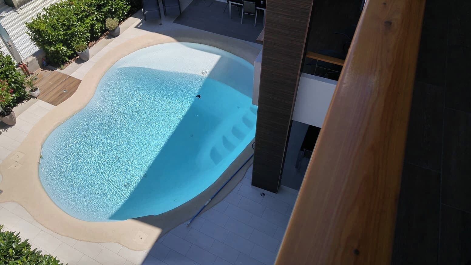 Una piscina al aire libre de temporada, tumbonas