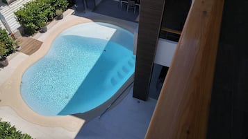 Una piscina al aire libre de temporada, tumbonas