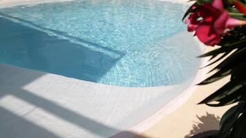 Una piscina al aire libre de temporada, sillones reclinables de piscina