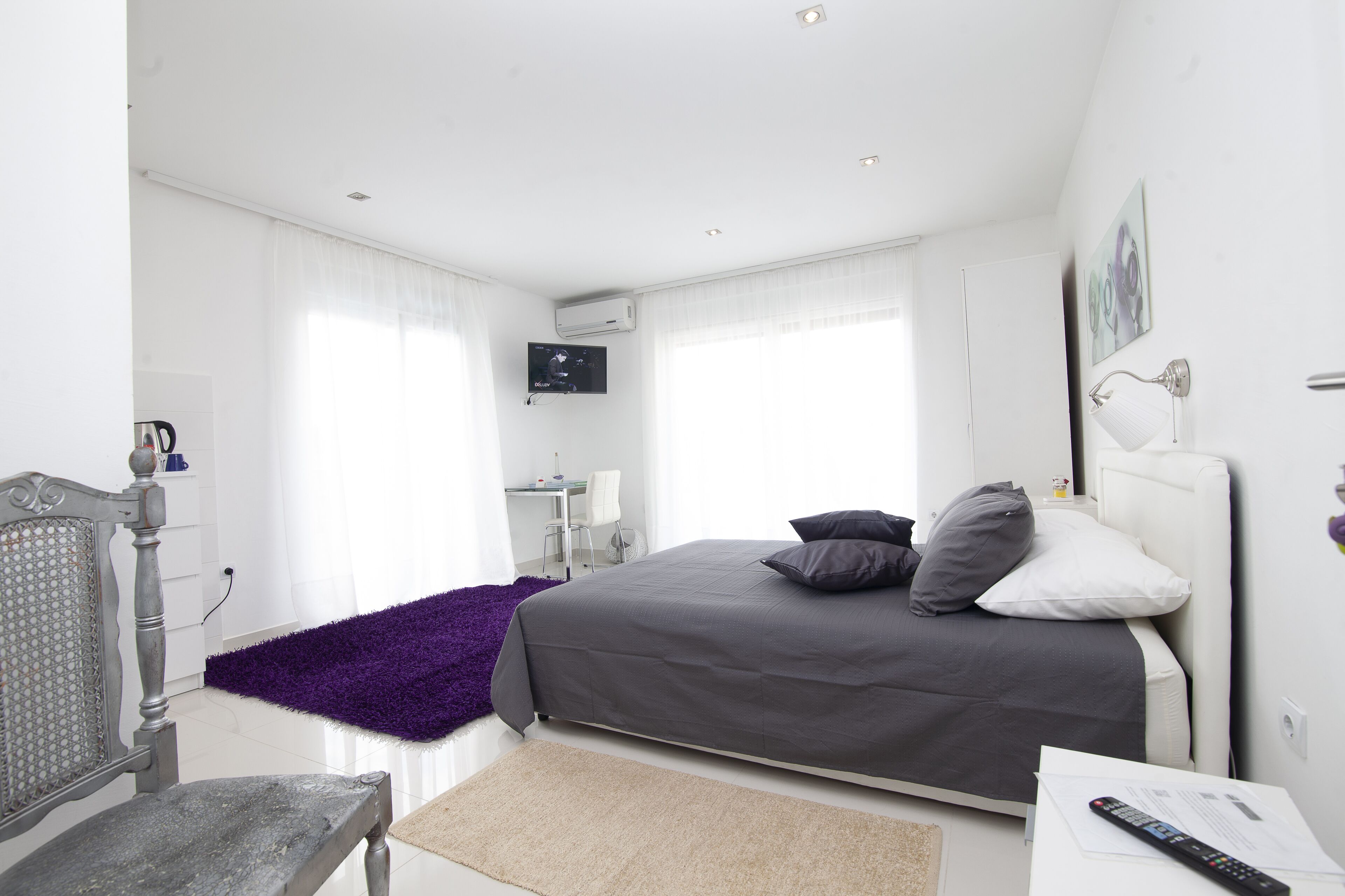 Un dormitorio moderno con una cama, un escritorio y una silla.