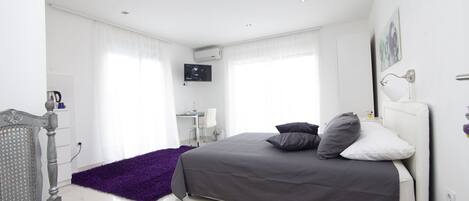 Un dormitorio moderno con una cama, un escritorio y una silla.