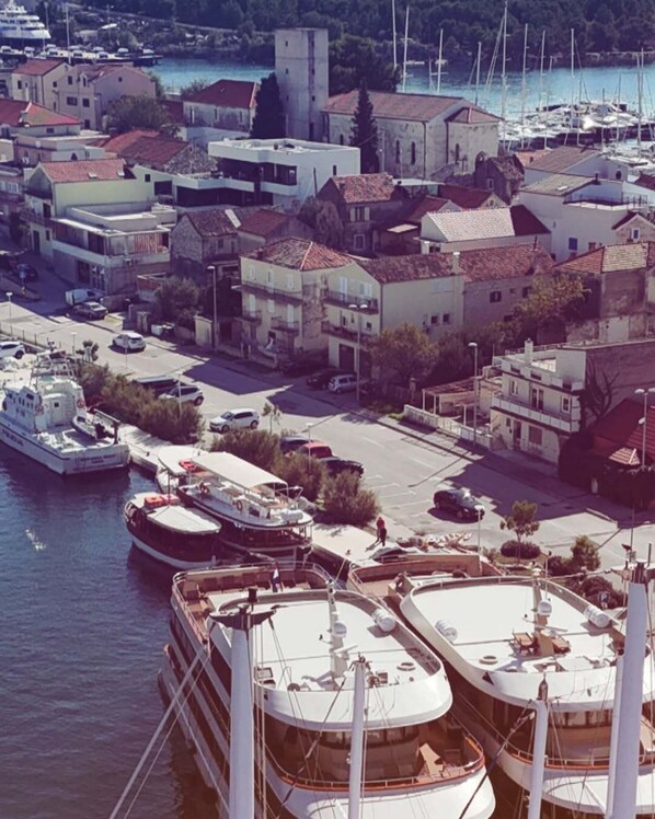 Un puerto deportivo con varias embarcaciones amarradas, rodeado de edificios residenciales con tejados de teja roja.