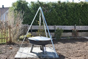 Un jardin avec un parterre surélevé, une balançoire et une clôture en bois.