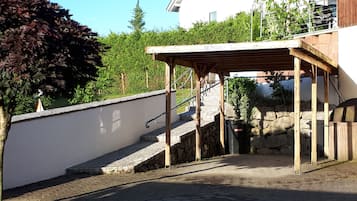 Eine Steintreppe führt zu einem hölzernen Pergola mit Metallgeländer.