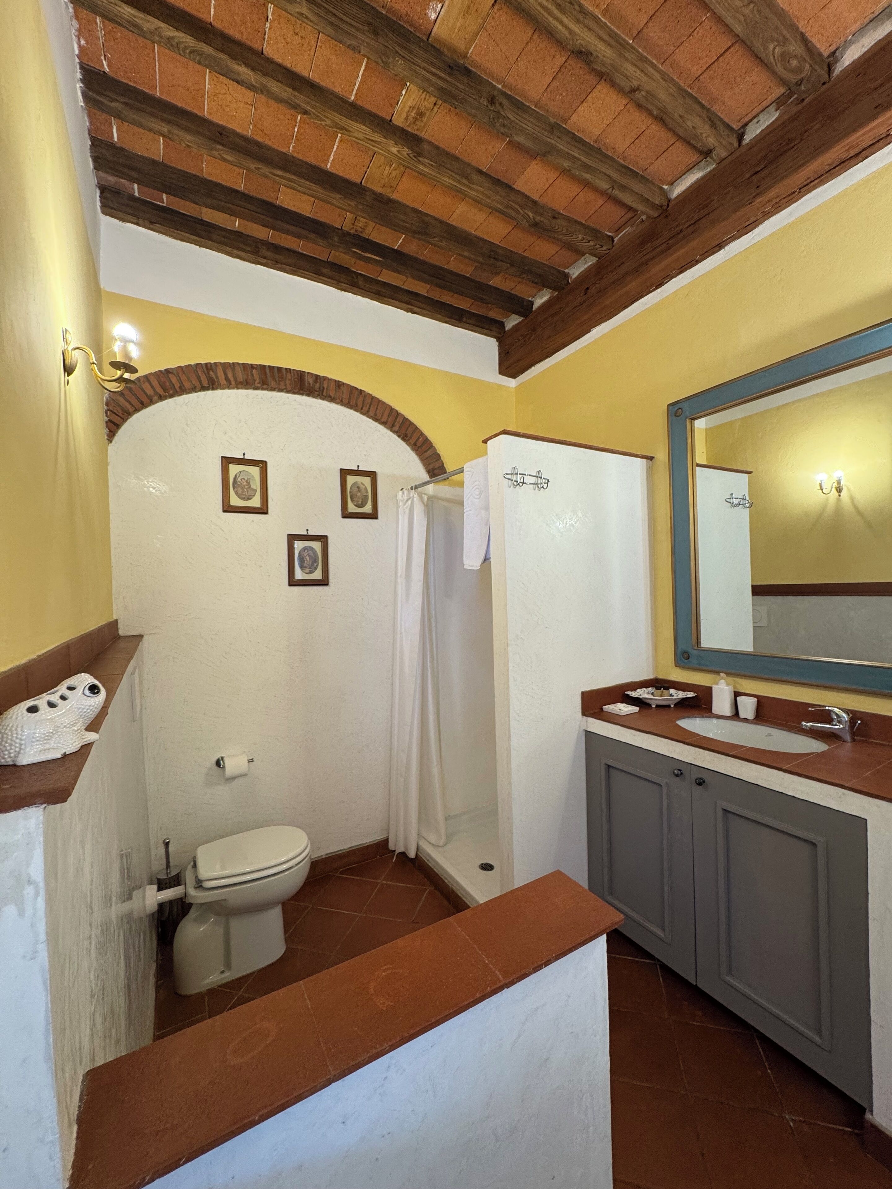 A bathroom with a toilet, shower, and sink.
