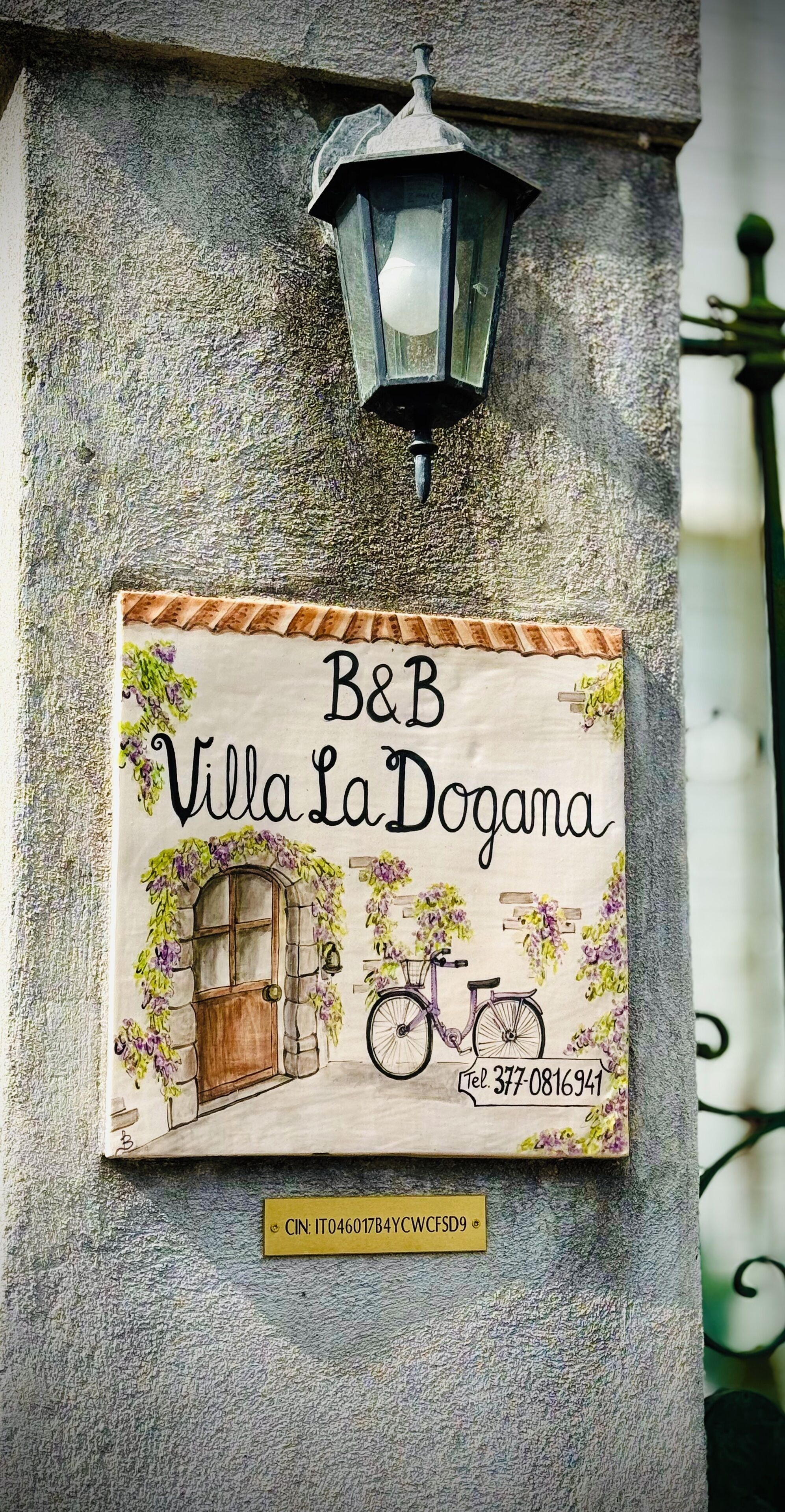 A sign for B&B Villa La Dogana with a contact number and a CNPJ.