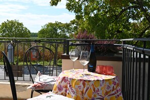 An outdoor dining area with a table set for two, featuring a bottle of wine and two glasses. - Hotel Al Sole - Preganziol (Preganziol)