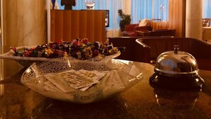 A hotel lobby with a marble reception desk, a decorative vase, and a chandelier. - Hotel Al Sole - Preganziol (Preganziol)
