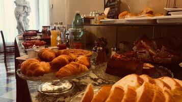 Un bufé de desayuno con cruasanes, pan y bollería.