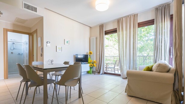 Una sala de estar moderna con comedor, un sofá y un televisor.
