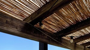 A wooden pergola structure with a view of a green landscape. - Agriturismo Fattoria La Prugnola (Montescudaio)