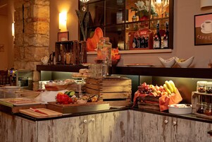 Un'area buffet con diversi cibi, una postazione caffè e una selezione di bevande.