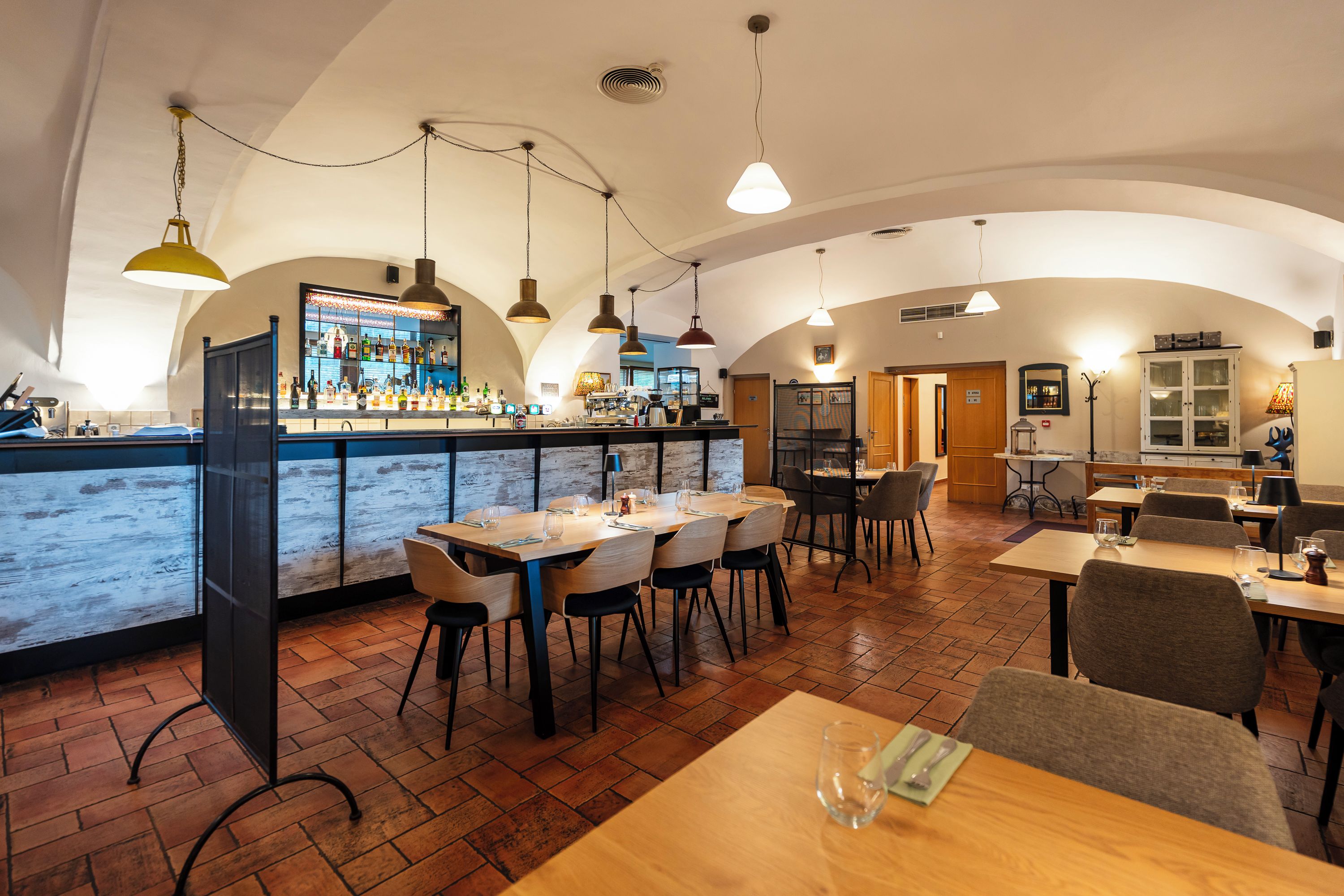 Un restaurante con barra, mesas y sillas de madera.