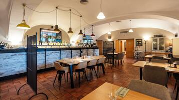 Un restaurante con barra, mesas y sillas de madera.