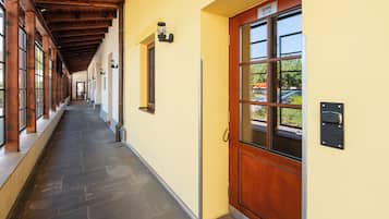 A hallway with a wooden ceiling, a yellow wall, and a door labeled 'Rooms 101-102'.