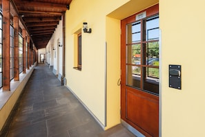 A hallway with a wooden ceiling, a yellow wall, and a door labeled 'Rooms 101-102'. - Hotel Chvalska Tvrz (Prague)
