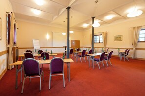 A conference room with tables and chairs, a whiteboard, and a window with curtains. - Hotel Chvalska Tvrz (Prague)