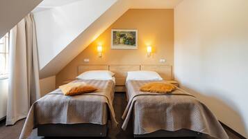Een hotelkamer met twee bedden, een schilderij aan de muur en twee wandlampen.
