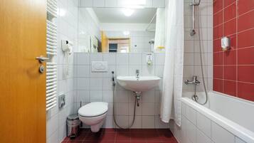Un baño pequeño con inodoro, lavabo y ducha.