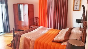 A bedroom with a bed, a wardrobe, a chair, and a bedside table.