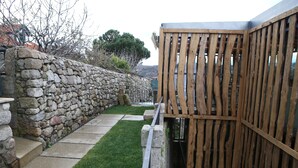A stone wall with a wooden fence and a paved pathway. - Muralha Charm House (Lamego)