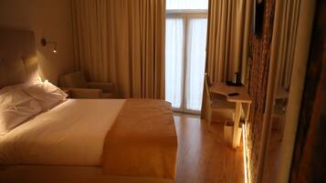 Una habitación de hotel con una cama grande, un escritorio y una silla.